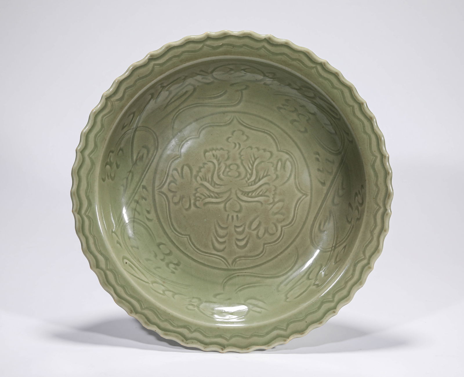 A LONGQUAN CELADON 'CARVED FLORAL' DISH: A LONGQUAN CELADON 'CARVED FLORAL' DISH Dimensions: Width: 34.2 cm (13.46 in) x Height: 6.3 cm (2.48 in). All measurements are approximate.