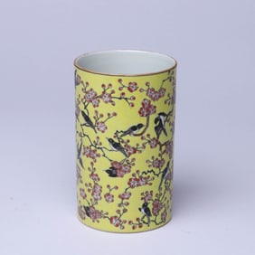 A YELLOW-GROUND FAMILLE ROSE 'MAGPIE ON PLUM BRANCH' BRUSH POT