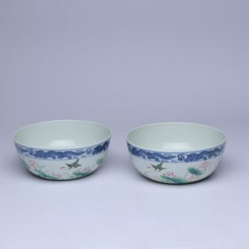A PAIR OF BLUE AND WHITE AND FAMILLE ROSE 'LOTUS POND' BOWLS