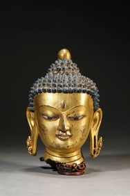 A GILT-BRONZE HEAD OF BUDDHA