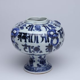 A BLUE AND WHITE 'LOTUS AND EIGHT BUDDHIST EMBLEMS AND SANSKRIT' BEAST-MASK STEM CUP