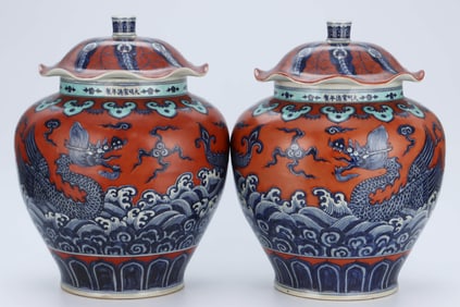 A PAIR OF BLUE AND WHITE AND IRON-RED 'WAVES AND DRAGON' LOTUS-LEAF COVERED JARS