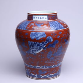 AN IRON-RED GROUND BLUE AND WHITE 'FISH AND WATER WEEDS' JAR