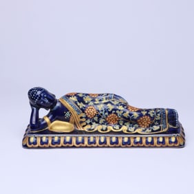 A BLUE-GROUND GILT RECUMBENT BUDDHA FIGURE
