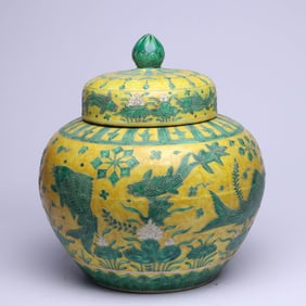 A YELLOW-GROUND SANCAI 'FISH AND WATER WEEDS' COVERED JAR