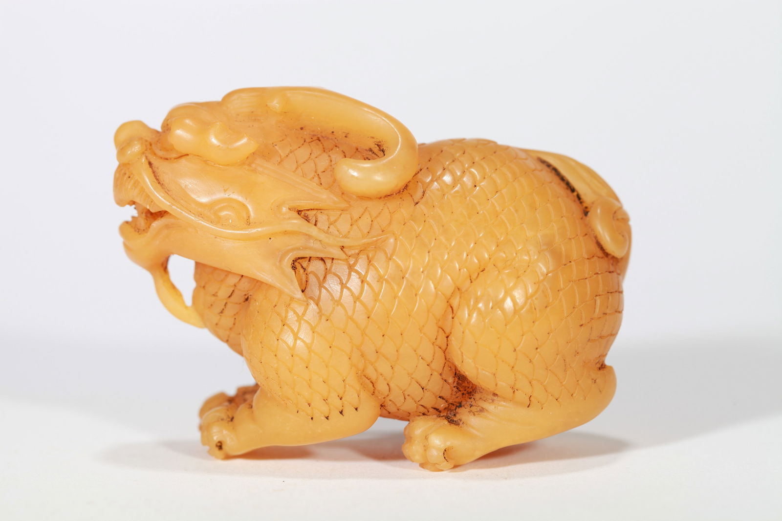 A TIANHUANG AUSPICIOUS BEAST HANDLE ORNAMENT: A TIANHUANG AUSPICIOUS BEAST HANDLE ORNAMENT Dimensions: Length: 6.5 cm (2.56 in.) x Height: 8.5 cm (3.35 in.). Weight: 121.5 g. All measurements are approximate.