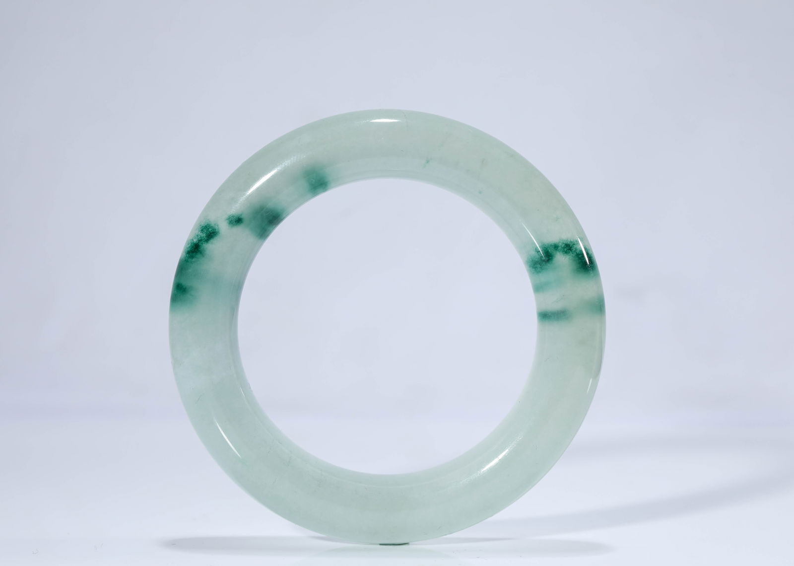 A JADEITE BANGLE: A JADEITE BANGLE Dimensions: Width: 8.9 cm (3.50 in). All measurements are approximate.