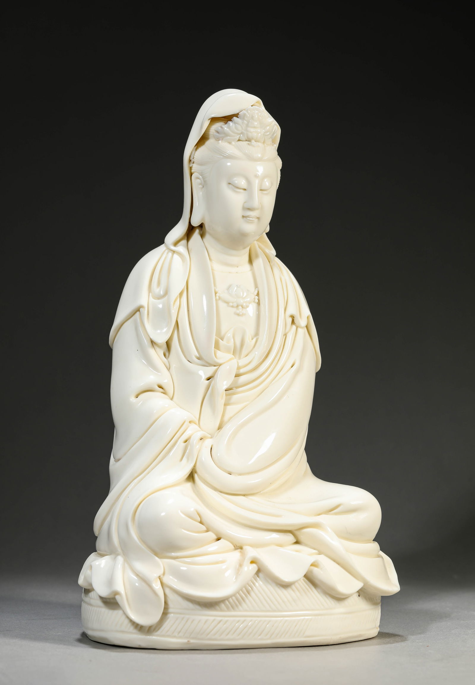 A DEHUA-TYPE 'RUYI-HOLDING' FIGURE OF AVALOKITESHVARA: A DEHUA-TYPE 'RUYI-HOLDING' FIGURE OF AVALOKITESHVARA Dimensions: Length: 17.3 cm (6.81 in) x Width: 14.2 cm (5.59 in) x Height: 29.8 cm (11.73 in). All measurements are approximate.