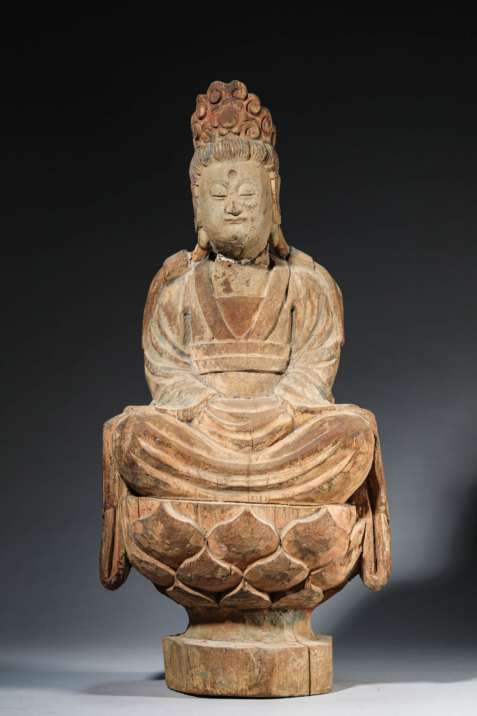 A WOOD SEATED FIGURE OF AVALOKITESHVARA: A WOOD SEATED FIGURE OF AVALOKITESHVARA Dimensions: Length: 27.0 cm (10.63 in) x Width: 18.0 cm (7.09 in) x Height: 53.0 cm (20.87 in). All measurements are approximate.