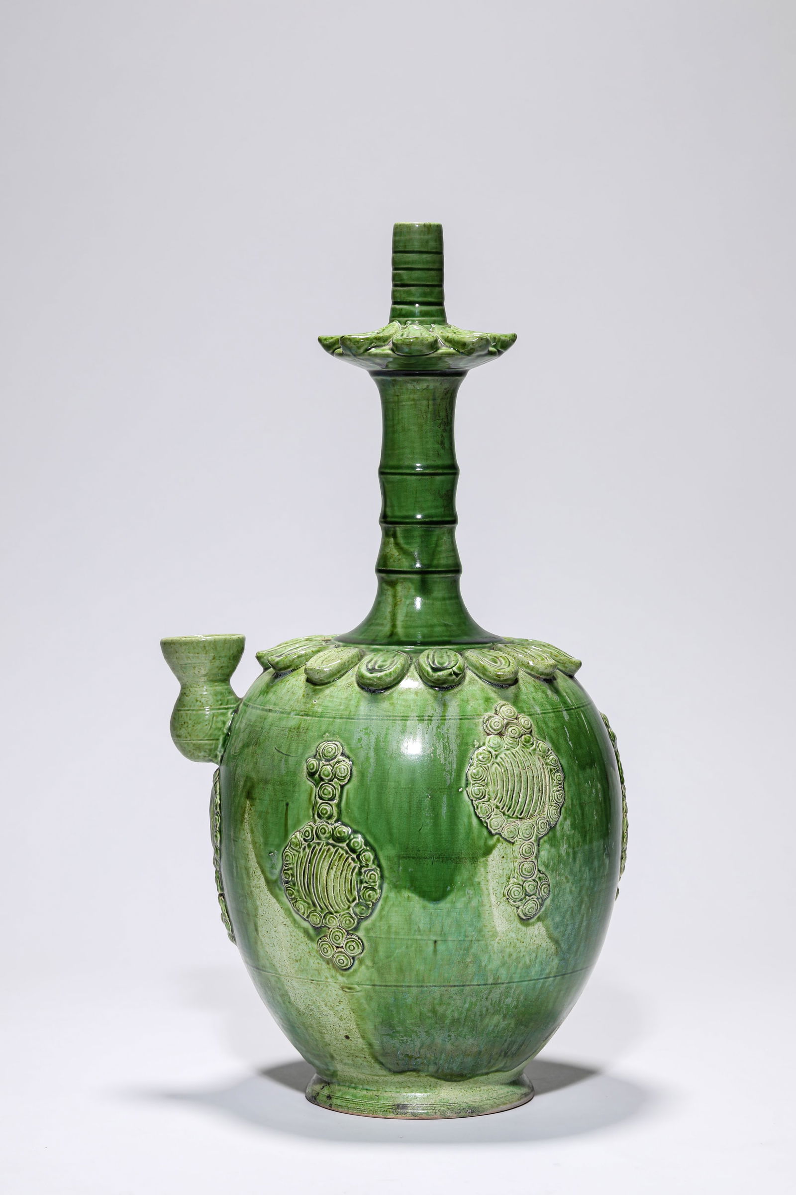 A GREEN-GLAZED KUNDIKA: A GREEN-GLAZED KUNDIKA Dimensions: Length: 20.0 cm (7.87 in) x Width: 16.8 cm (6.61 in) x Height: 37.5 cm (14.76 in). All measurements are approximate.