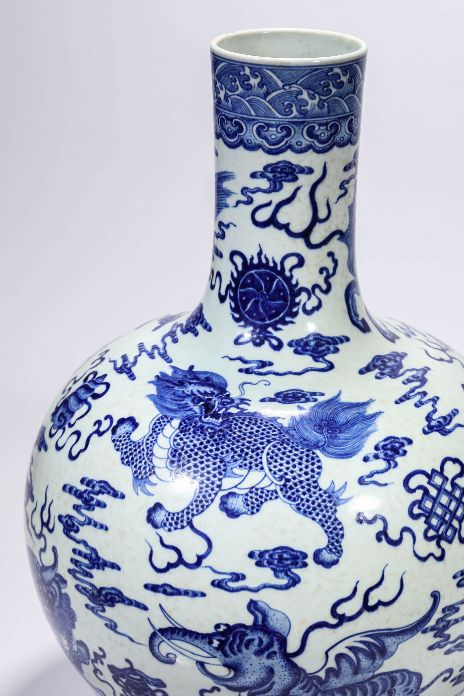 A BLUE AND WHITE 'AUSPICIOUS BEASTS AND EIGHT BUDDHIST EMBLEMS' CORAL-GROUND BOTTLE VASE: A BLUE AND WHITE 'AUSPICIOUS BEASTS AND EIGHT BUDDHIST EMBLEMS' CORAL-GROUND BOTTLE VASE Dimensions: Width: 37.2 cm (14.65 in) x Height: 52.9 cm (20.83 in). All measurements are approximate.