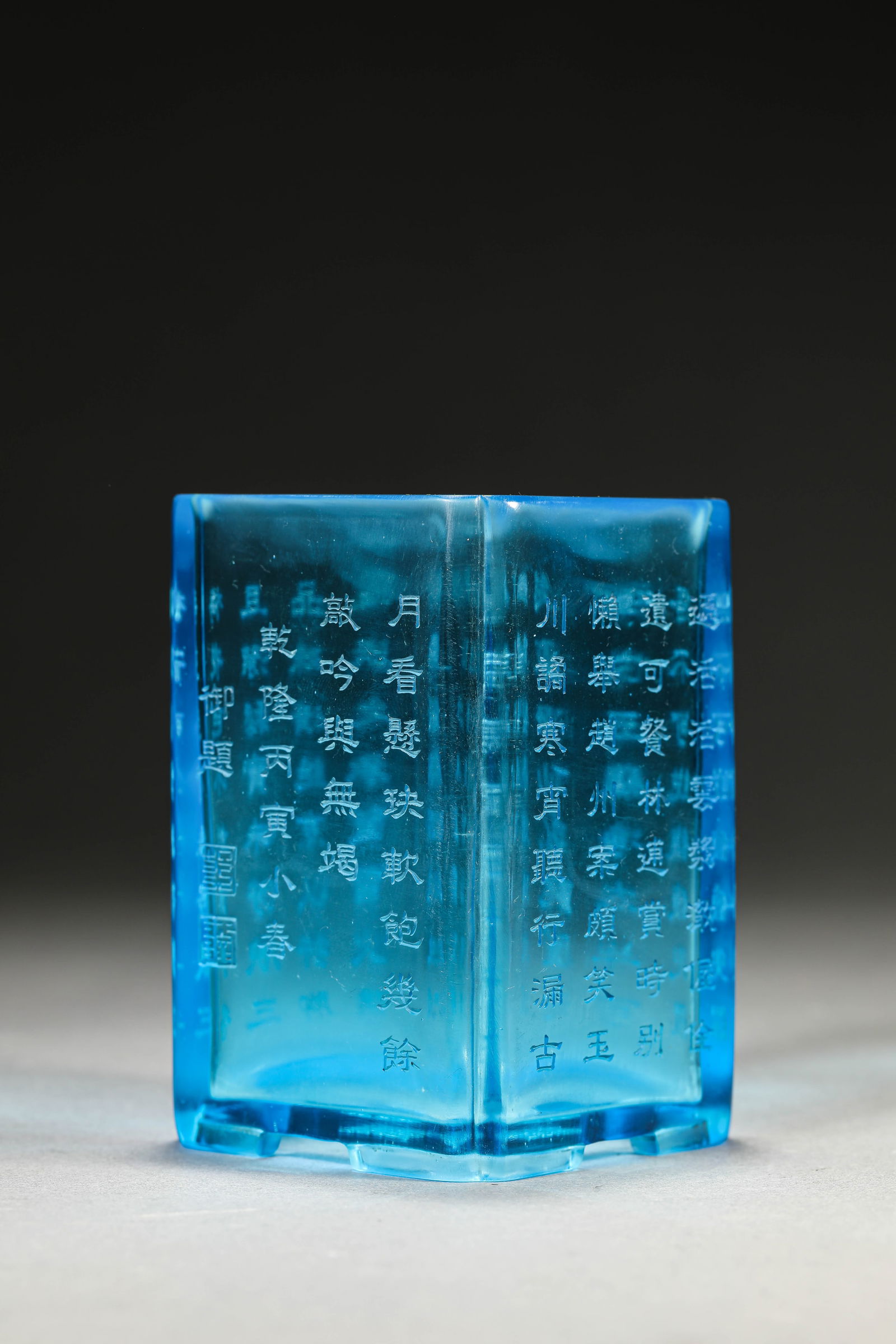 A BLUE-GLASS 'POETIC INSCRIPTION' BRUSH POT: A BLUE-GLASS 'POETIC INSCRIPTION' BRUSH POT Dimensions: Length: 6.6 cm (2.60 in) x Width: 6.6 cm (2.60 in) x Height: 9.8 cm (3.86 in). All measurements are approximate.