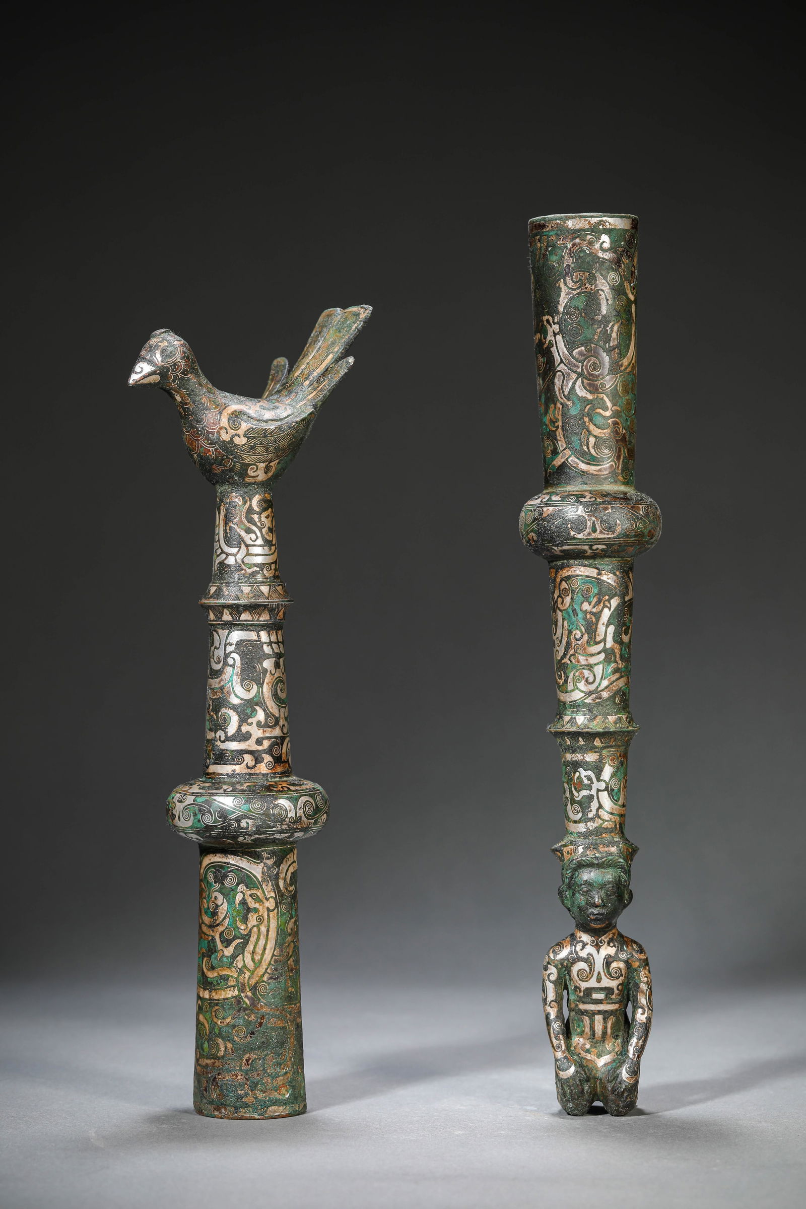 A SILVER-INLAID BRONZE STAFF FINIAL AND FERRULE: A SILVER-INLAID BRONZE STAFF FINIAL AND FERRULE Dimensions: Weight: 1236g. Length: 8.6 cm (3.39 in) x Width: 5.4 cm (2.13 in) x Height: 27.2 cm (10.71 in). Width: 4.8 cm (1.89 in) x Height: 30.2 cm