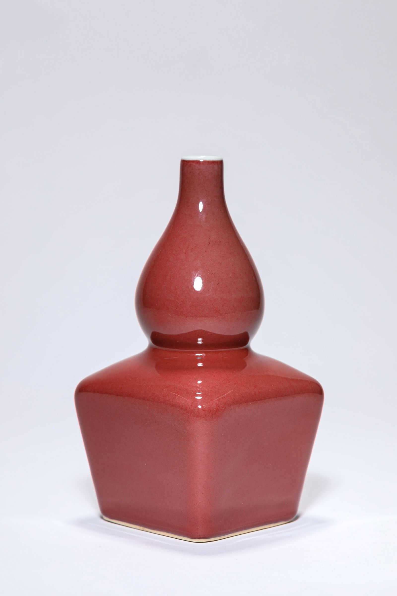 A RED-GLAZED 'DOUBLE-GOURD' VASE: A RED-GLAZED 'DOUBLE-GOURD' VASE Dimensions: Width: 9.5 cm (3.74 in) x Height: 18.1 cm (7.13 in). All measurements are approximate.