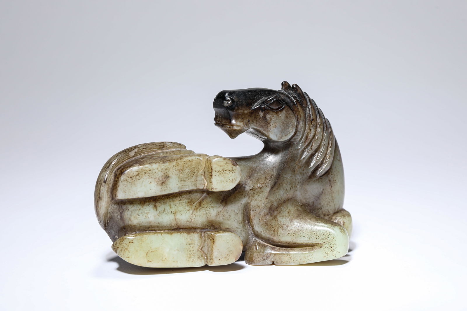 A JADE RECUMBENT HORSE: A JADE RECUMBENT HORSE Dimensions: Length: 14.0 cm (5.51 in) x Width: 6.7 cm (2.64 in) x Height: 9.1 cm (3.58 in). All measurements are approximate.