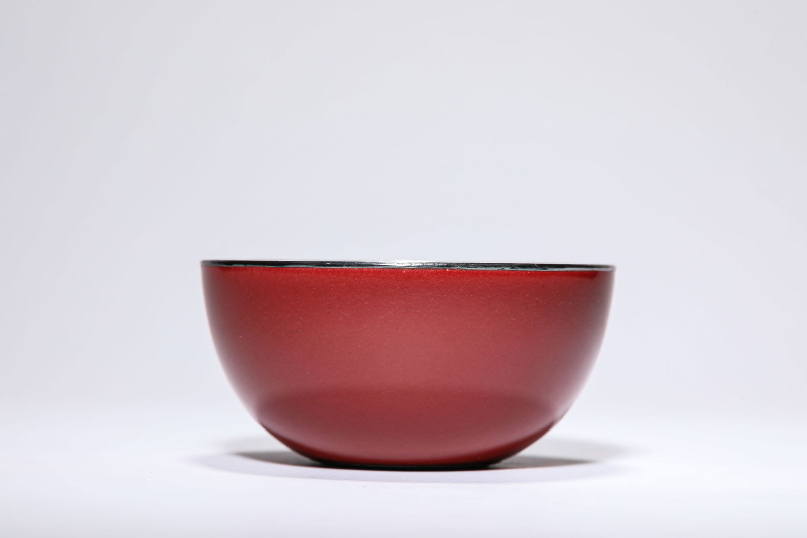 A RED-GLAZED SILVER-MOUNTED BOWL: A RED-GLAZED SILVER-MOUNTED BOWL Dimensions: Width: 10.8 cm (4.25 in) x Height: 5.0 cm (1.97 in). All measurements are approximate.