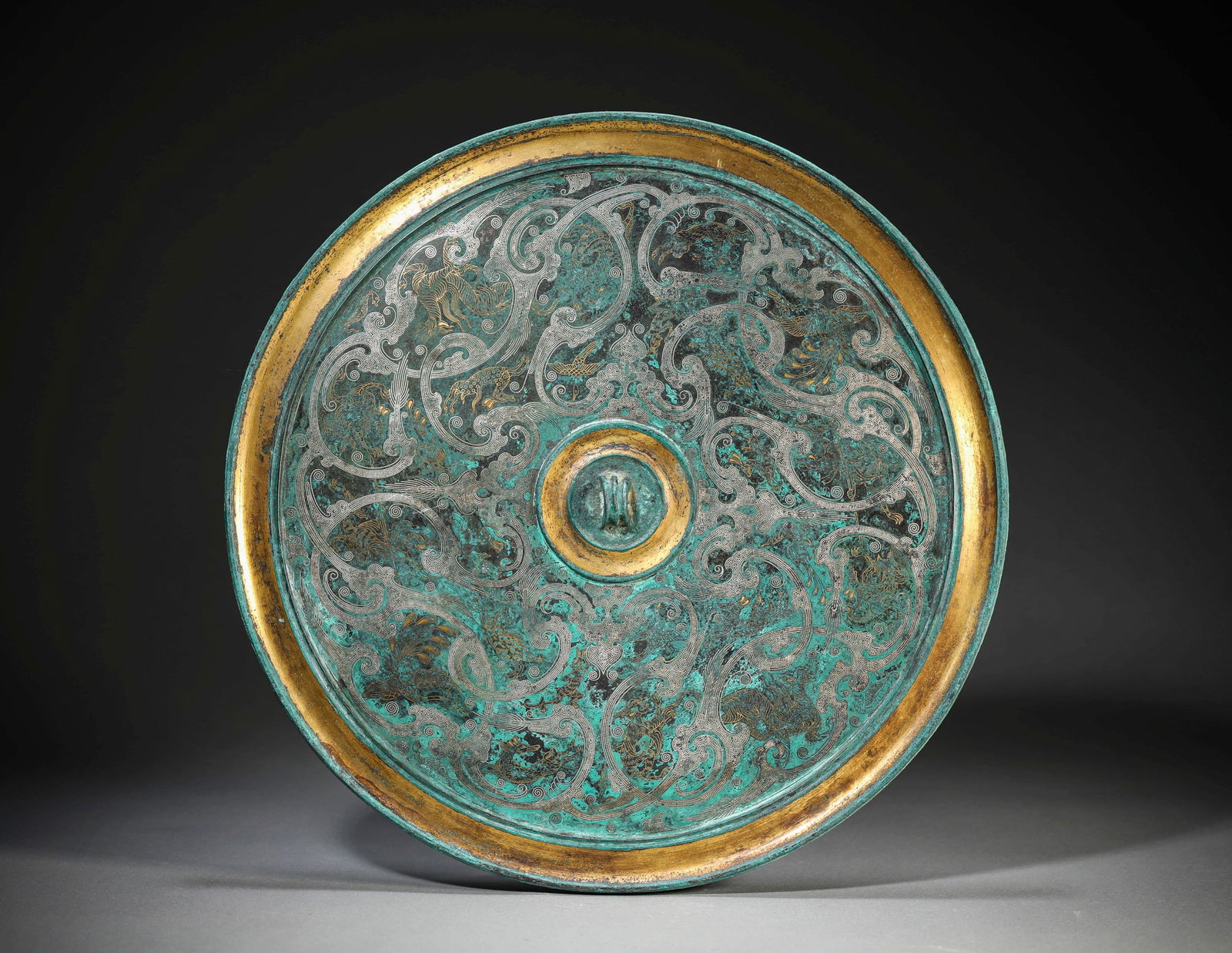 A GOLD AND SILVER-INLAID BRONZE 'AUSPICIOUS BEAST' MIRROR: A GOLD AND SILVER-INLAID BRONZE 'AUSPICIOUS BEAST' MIRROR Dimensions: Weight: 1831g. Width: 29.1 cm (11.46 in). All measurements are approximate.