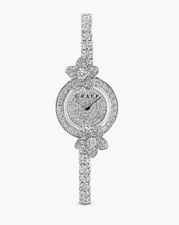 WILD FLOWER DIAMOND WRISTWATCH: WILD FLOWER DIAMOND WRISTWATCHDescription:The elegant and distinctive 18K white gold Wild Flower watch features two diamond flowers connected by a circle of closely set diamonds, paired with a round