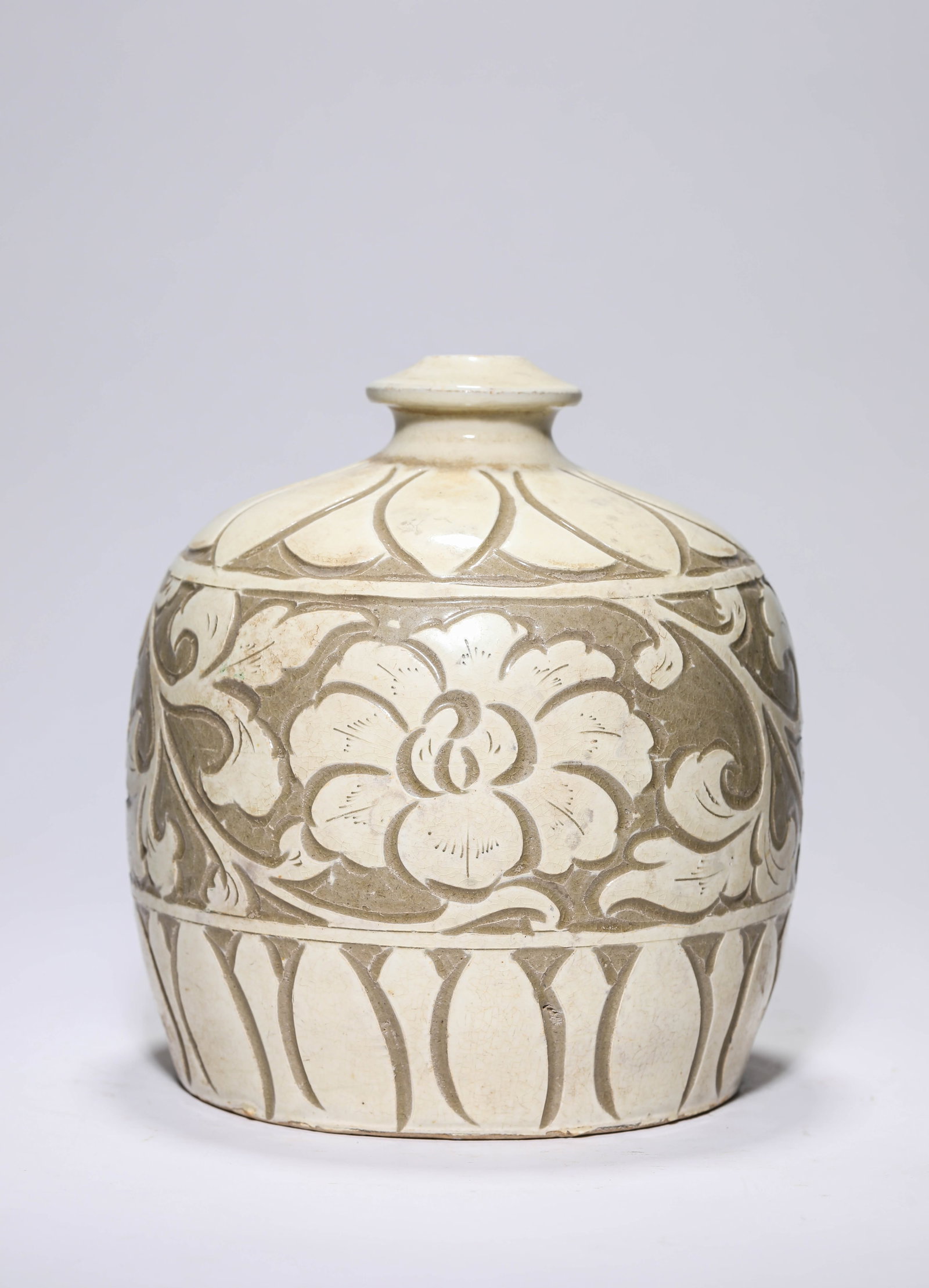 A CIZHOU-TYPE 'CARVED FLORAL' EWER: A CIZHOU-TYPE 'CARVED FLORAL' EWER Dimensions: Width: 17.8 cm (7.01 in) x Height: 20.6 cm (8.11 in). All measurements are approximate.