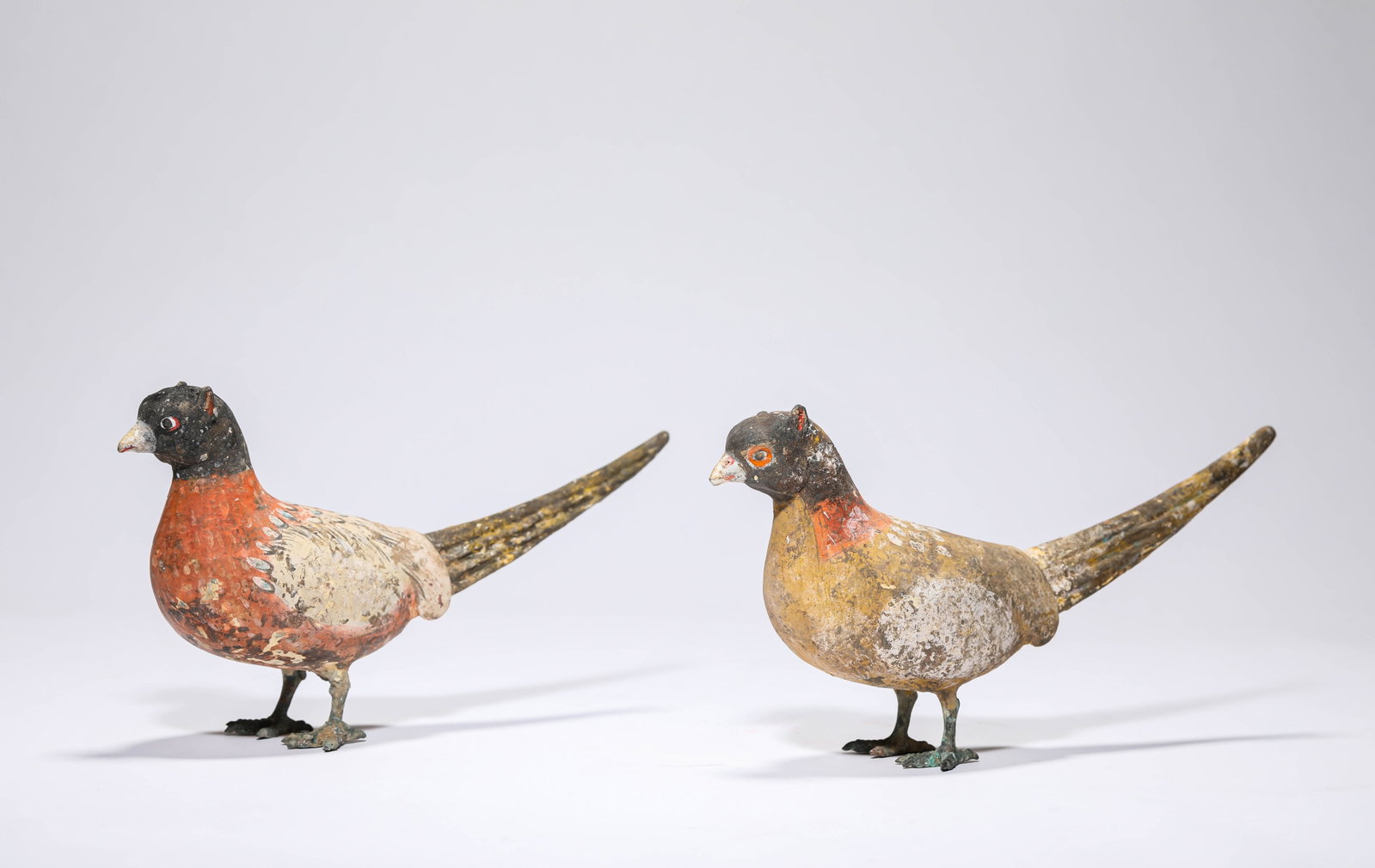 A PAIR OF PAINTED POTTERY BIRDS: A PAIR OF PAINTED POTTERY BIRDS Dimensions: Length: 19.8 cm (7.80 in) x Width: 5.2 cm (2.05 in) x Height: 10.9 cm (4.29 in). All measurements are approximate.