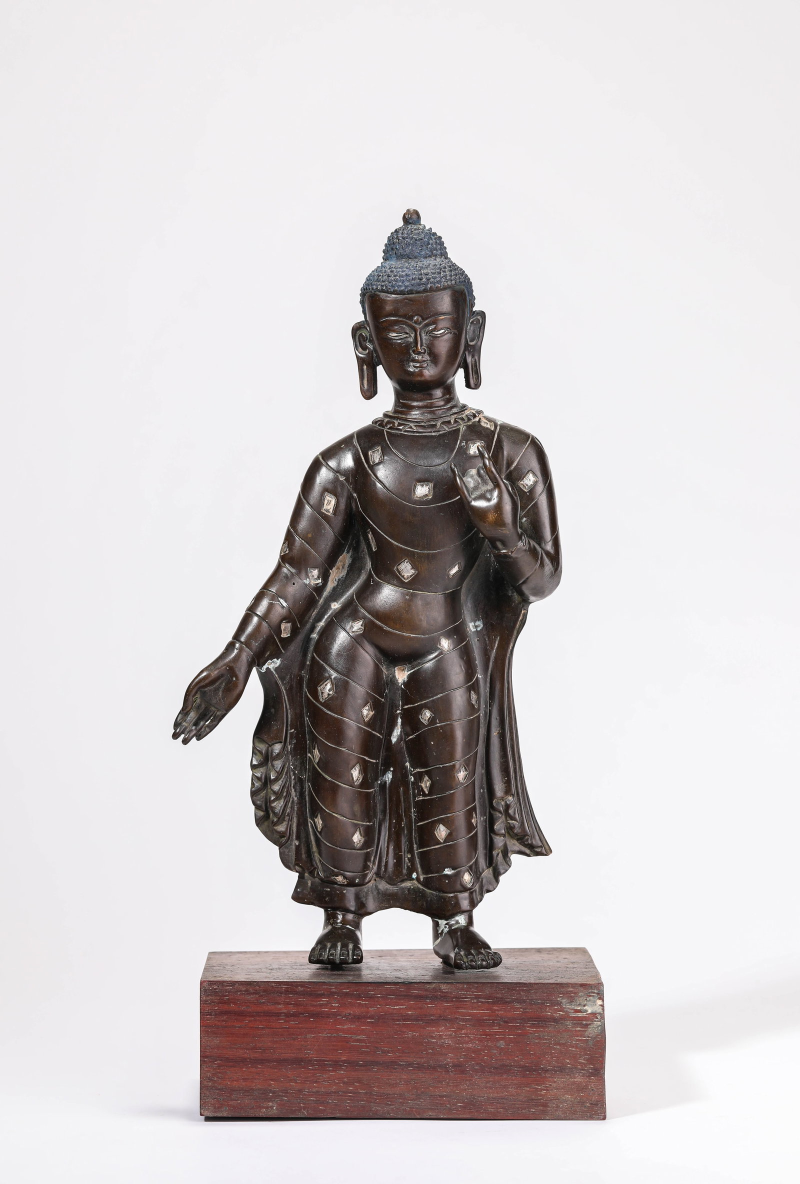 A BRONZE STANDING FIGURE OF SHAKYAMUNI: A BRONZE STANDING FIGURE OF SHAKYAMUNI Dimensions: Weight: 1660g. Length: 14.8 cm (5.83 in) x Width: 10.1 cm (3.98 in) x Height: 33.5 cm (13.19 in). All measurements are approximate.