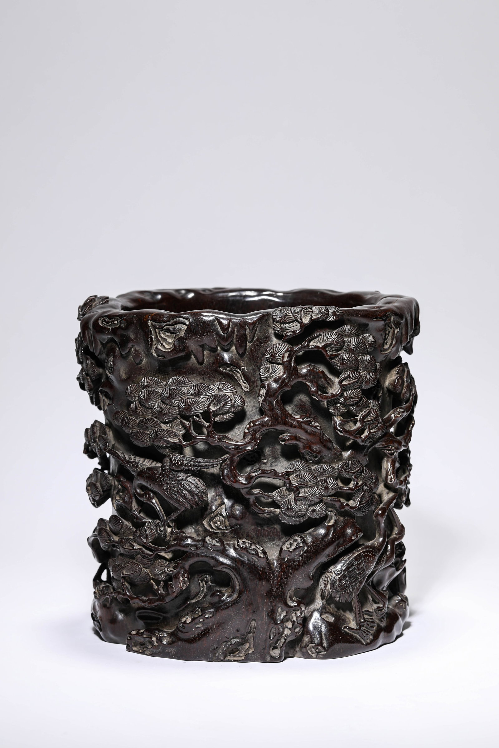 A WOOD 'CARVED PINE AND CRANE' BRUSH POT: A WOOD 'CARVED PINE AND CRANE' BRUSH POT Dimensions: Length: 21.2 cm (8.35 in) x Width: 19.4 cm (7.64 in) x Height: 21.6 cm (8.50 in). All measurements are approximate.