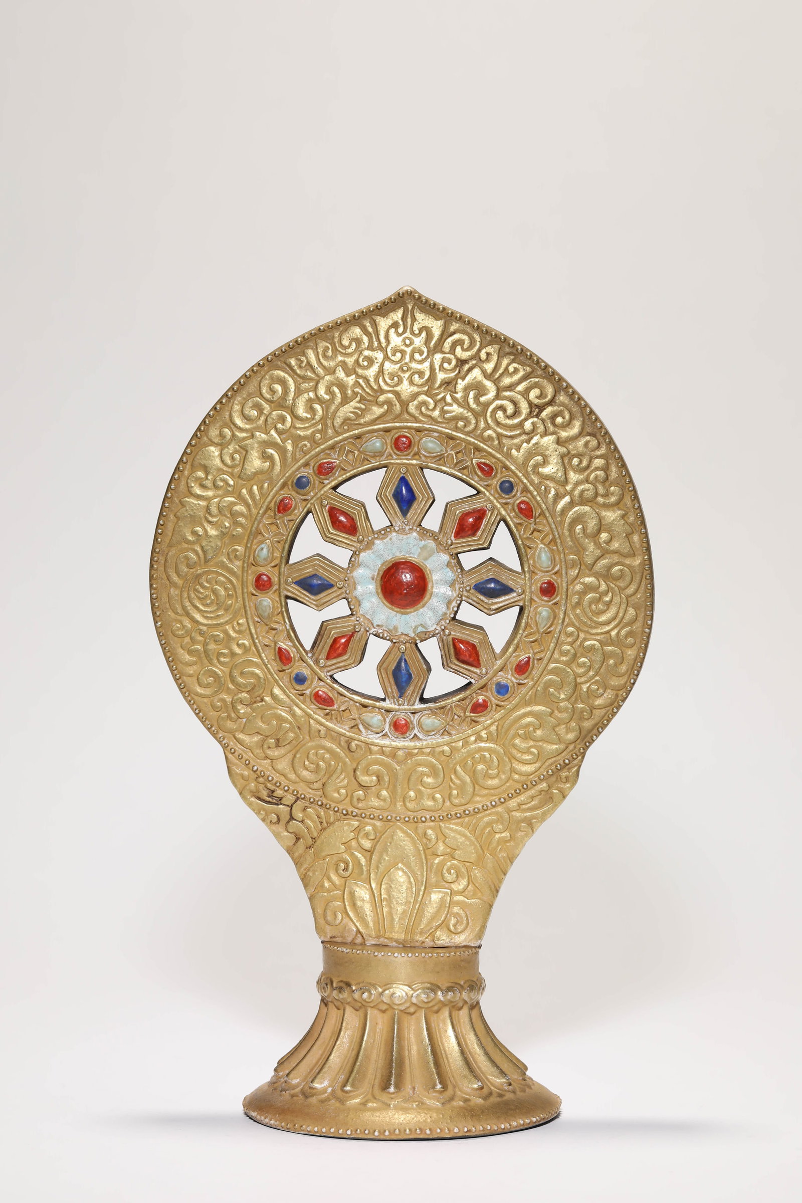 A 'GOLD-GLAZED IMITATION' DHARMA WHEEL: A 'GOLD-GLAZED IMITATION' DHARMA WHEEL Dimensions: Length: 17.0 cm (6.69 in) x Width: 10.9 cm (4.29 in) x Height: 27.5 cm (10.83 in). All measurements are approximate.