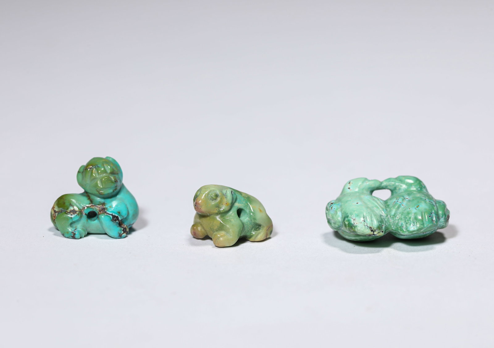 A GROUP OF TURQUOISE 'AUSPICIOUS BEASTS': A GROUP OF TURQUOISE 'AUSPICIOUS BEASTS' Dimensions: Width: 2.1 cm (0.83 in) x Height: 1.5 cm (0.59 in). All measurements are approximate.