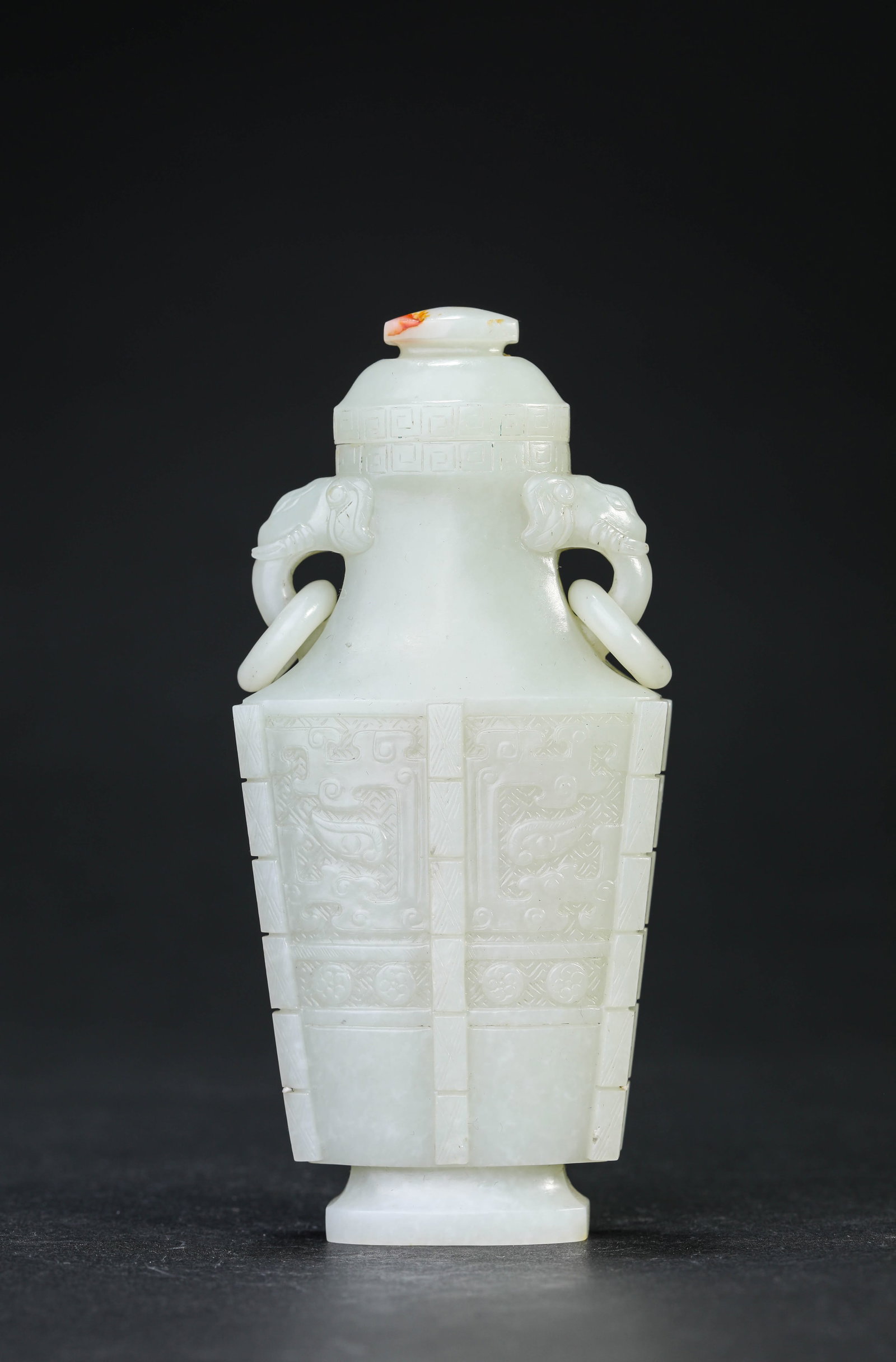 A JADE 'TAOTIE' 'ELEPHANT-HEAD HANDLES' COVERED VASE: A JADE 'TAOTIE' 'ELEPHANT-HEAD HANDLES' COVERED VASE Dimensions: Length: 6.2 cm (2.44 in) x Width: 3.2 cm (1.26 in) x Height: 13.3 cm (5.24 in). All measurements are approximate.