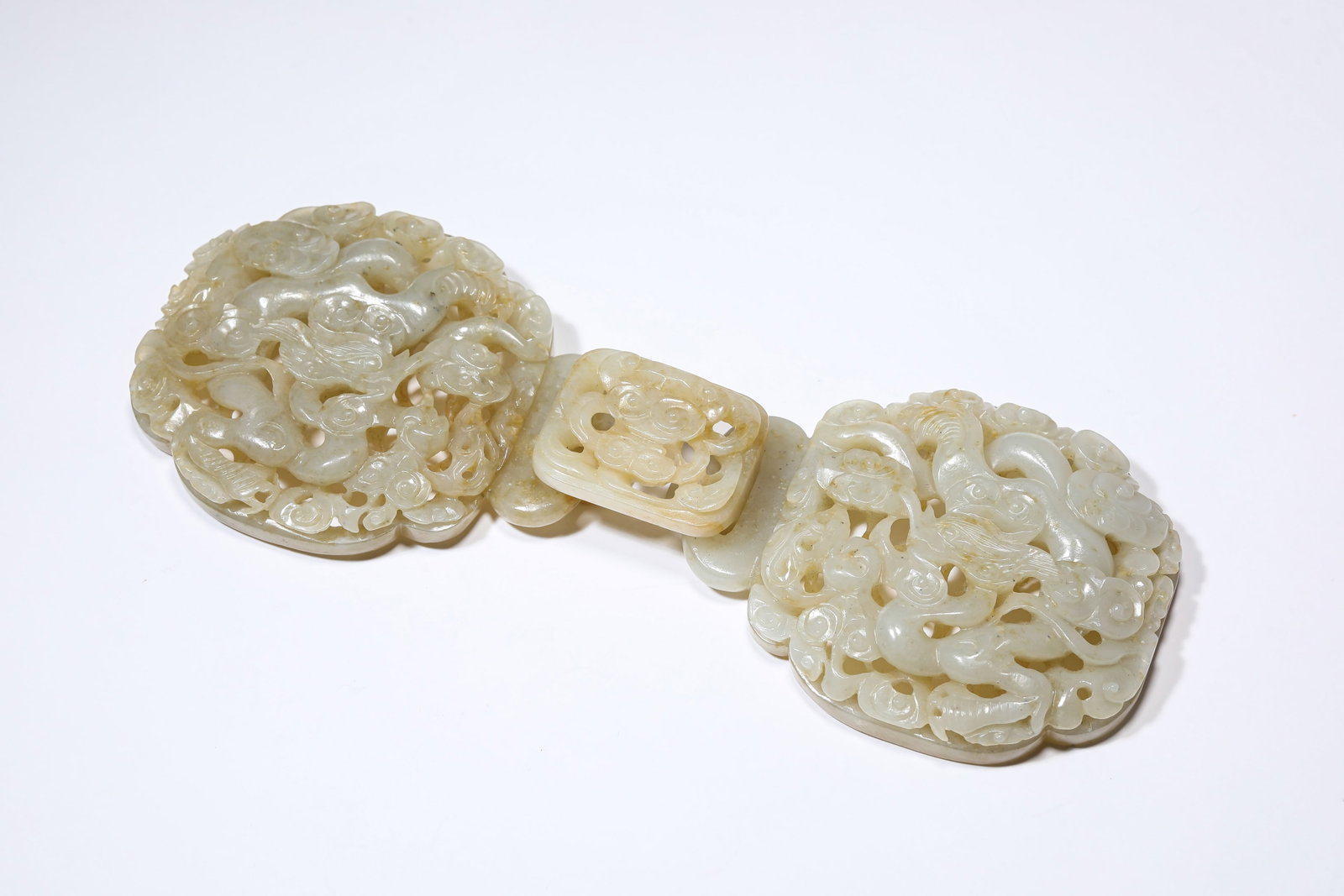A JADE 'DRAGON AND CLOUDS' BELT BUCKLE: A JADE 'DRAGON AND CLOUDS' BELT BUCKLE Dimensions: Width: 20.0 cm (7.87 in) x Height: 7.2 cm (2.83 in). All measurements are approximate.
