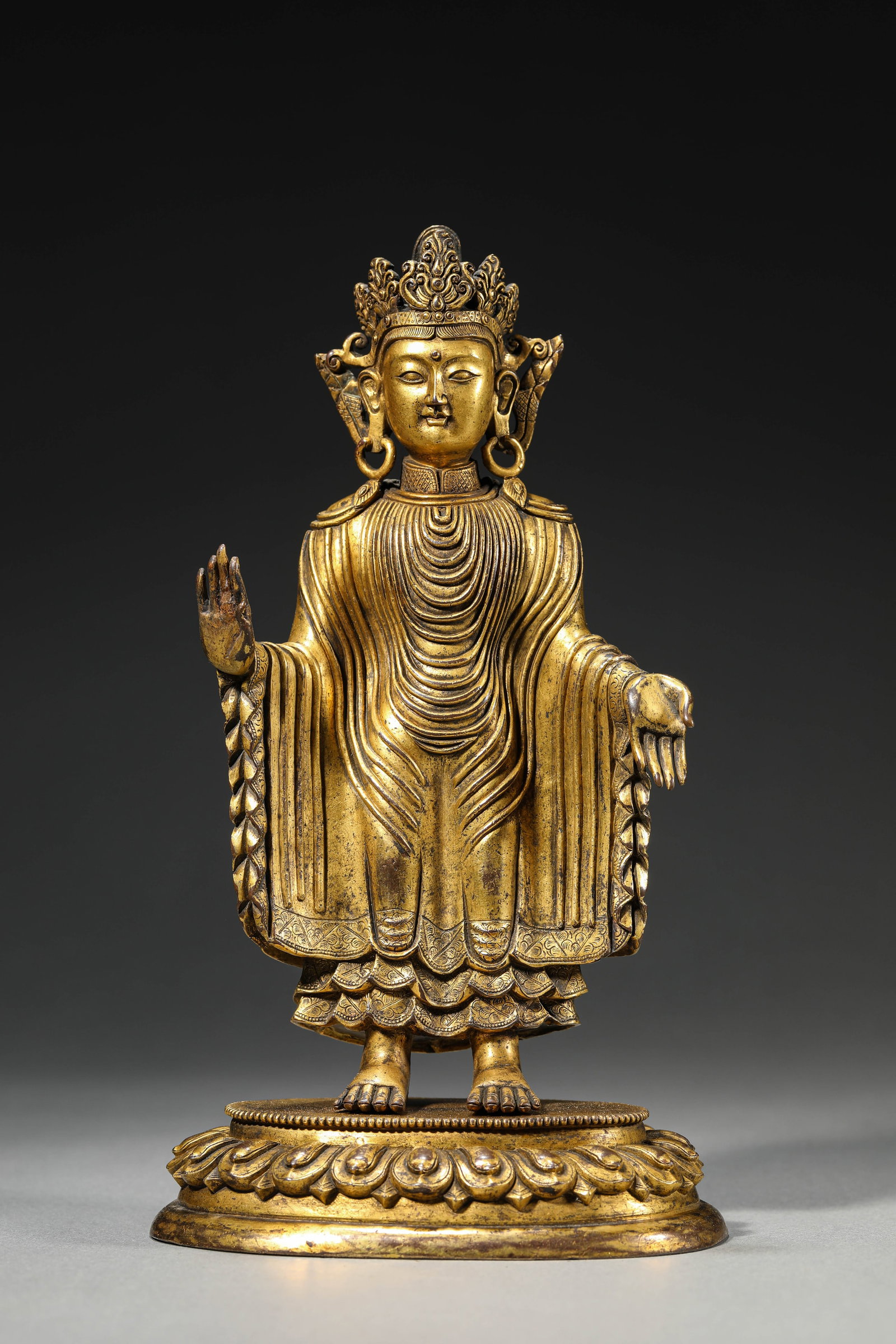 A GILT-BRONZE FIGURE OF THE SANDALWOOD BUDDHA: A GILT-BRONZE FIGURE OF THE SANDALWOOD BUDDHA Dimensions: Weight: 1640g. Length: 13.0 cm (5.12 in) x Width: 9.0 cm (3.54 in) x Height: 23.5 cm (9.25 in). All measurements are approximate.