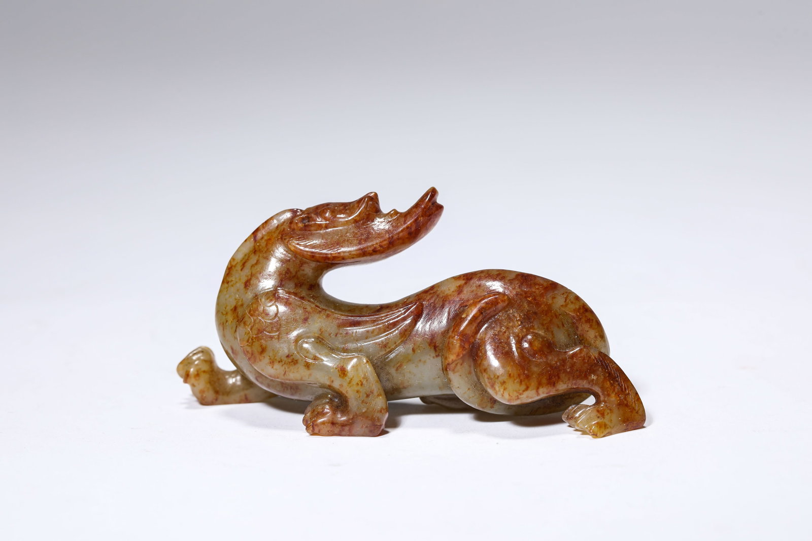 A JADE 'AUSPICIOUS BEAST': A JADE 'AUSPICIOUS BEAST' Dimensions: Length: 9.3 cm (3.66 in) x Width: 2.3 cm (0.91 in) x Height: 4.3 cm (1.69 in). All measurements are approximate.