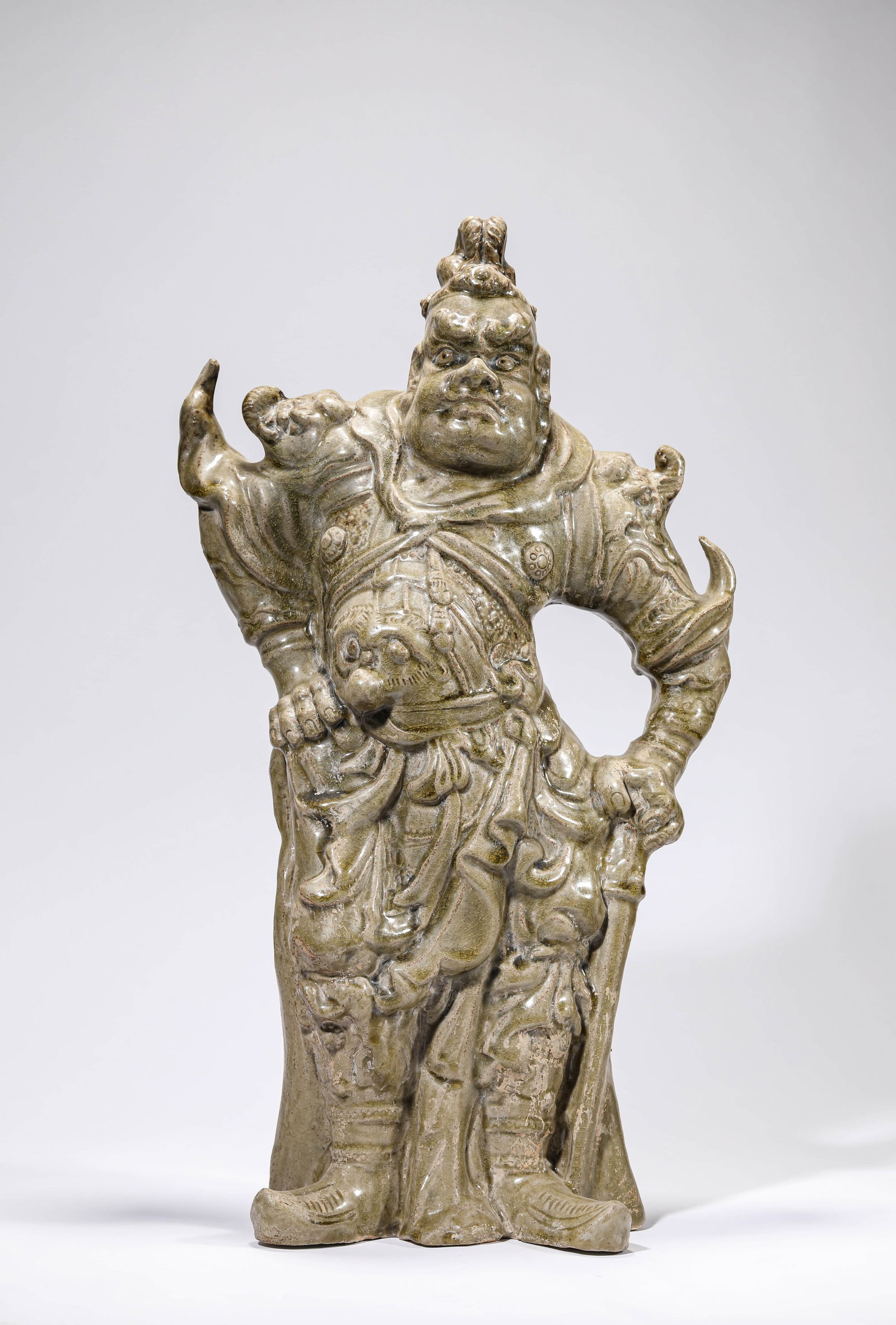 A CELADON FIGURE OF A GUARDIAN: A CELADON FIGURE OF A GUARDIAN Dimensions: Length: 28.4 cm (11.18 in) x Width: 13.3 cm (5.24 in) x Height: 52.0 cm (20.47 in). All measurements are approximate.