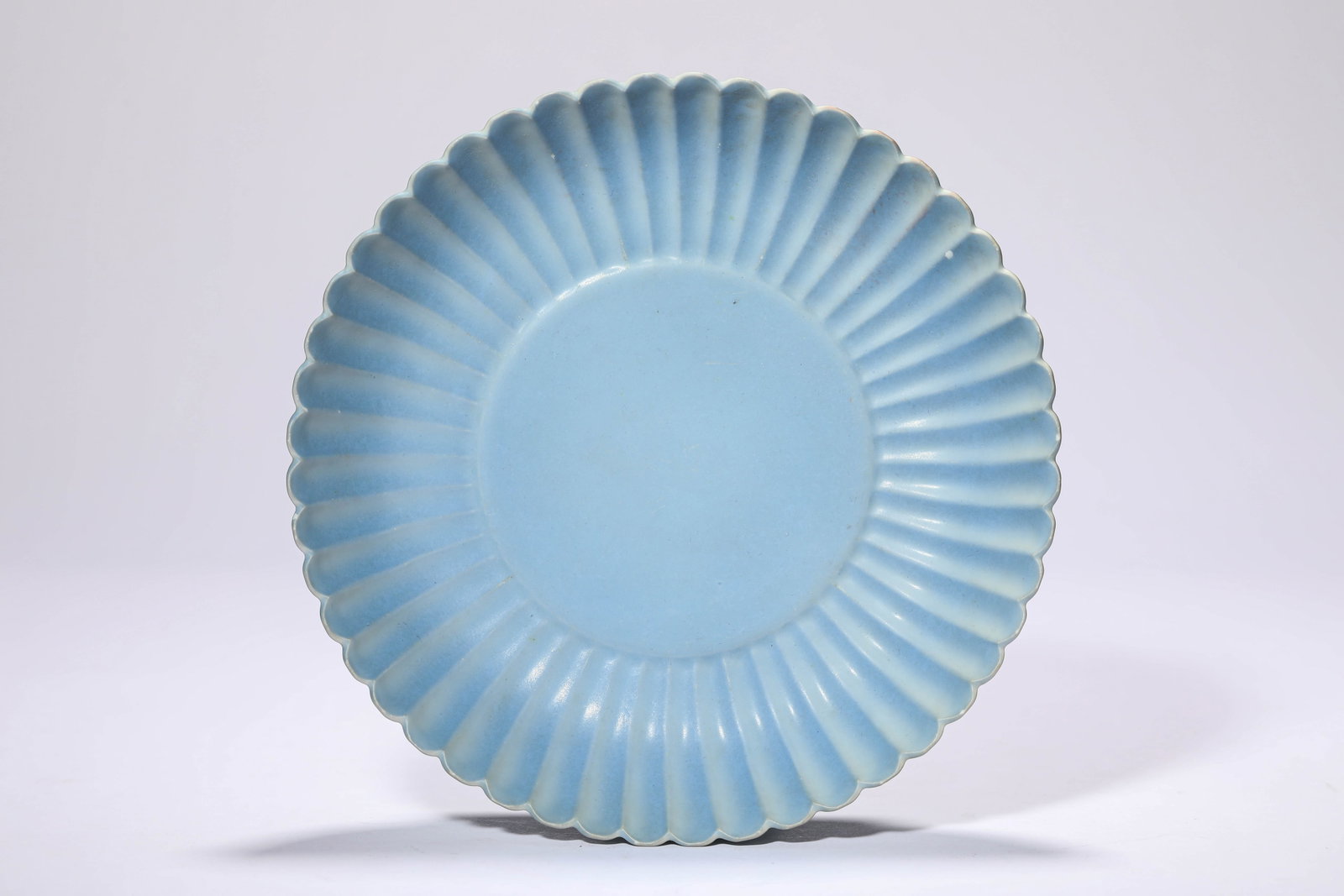 A SKY-BLUE-GLAZED CHRYSANTHEMUM-PETAL SHAPED DISH: A SKY-BLUE-GLAZED CHRYSANTHEMUM-PETAL SHAPED DISH Dimensions: Width: 18.7 cm (7.36 in) x Height: 4.0 cm (1.57 in). All measurements are approximate.