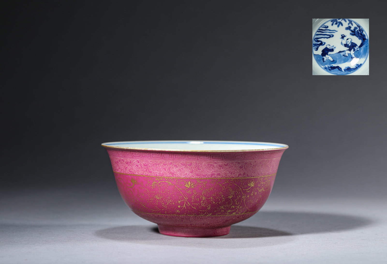 A RUBY RED GROUND 'GILT-DECORATED FLORAL' INTERIOR BLUE AND WHITE 'CHILDREN AT PLAY' BOWL: A RUBY RED GROUND 'GILT-DECORATED FLORAL' INTERIOR BLUE AND WHITE 'CHILDREN AT PLAY' BOWL Dimensions: Width: 15.5 cm (6.10 in) x Height: 7.4 cm (2.91 in). All measurements are approximate.