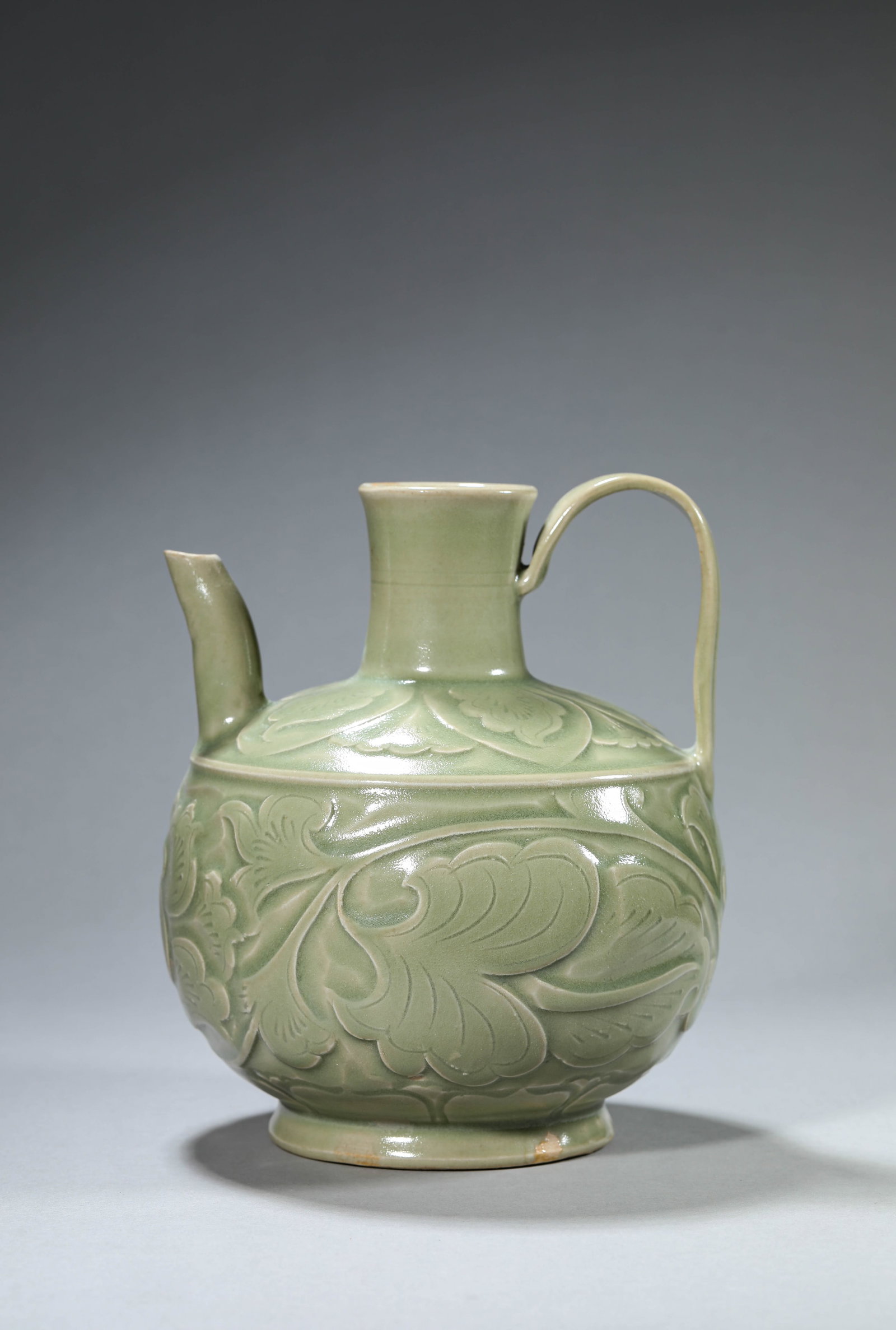 A YAOZHOU-TYPE 'CARVED PEONY' EWER: A YAOZHOU-TYPE 'CARVED PEONY' EWER Dimensions: Width: 16.1 cm (6.34 in) x Height: 18.4 cm (7.24 in). All measurements are approximate.