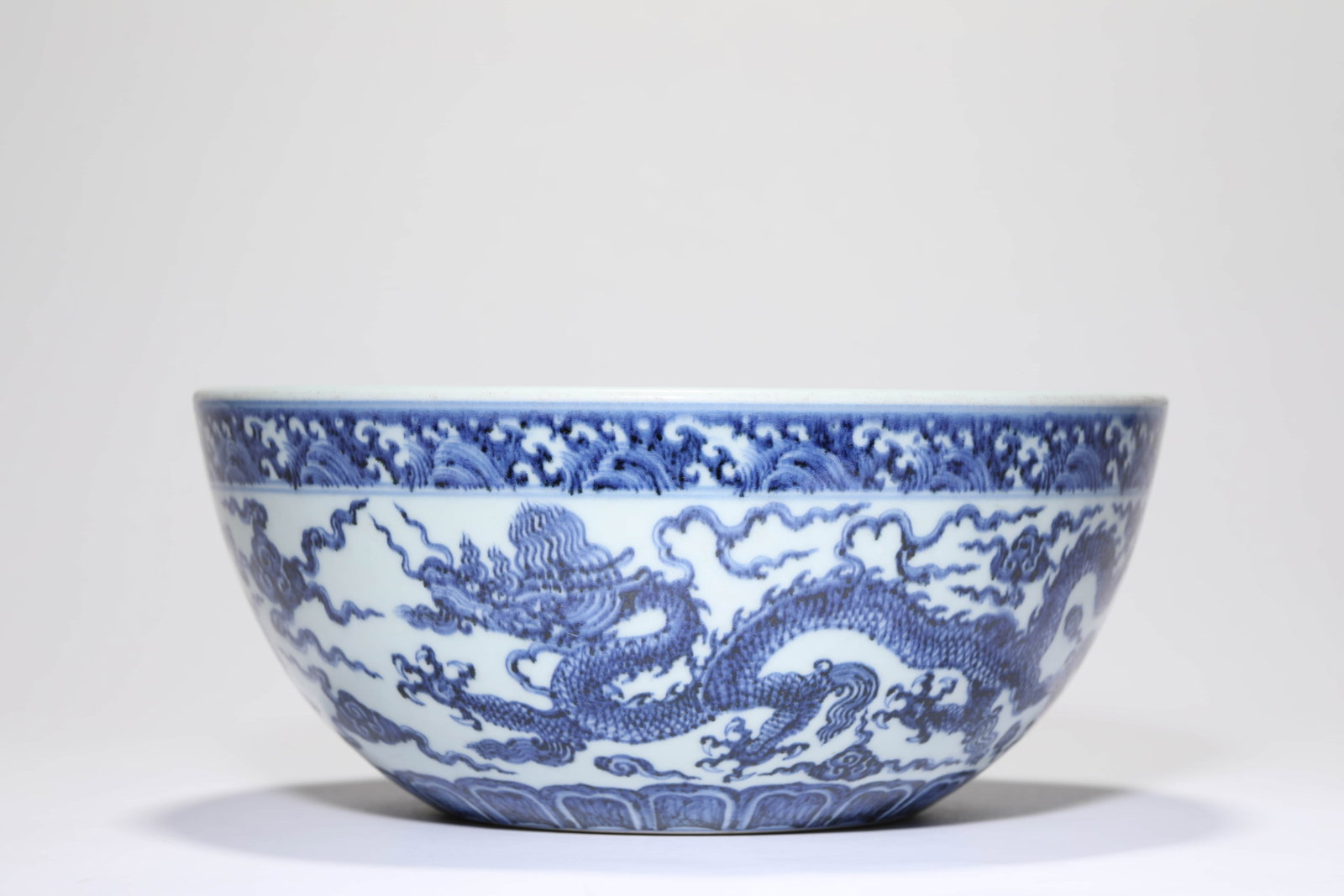 A BLUE AND WHITE 'DRAGON AND CLOUDS' BOWL: A BLUE AND WHITE 'DRAGON AND CLOUDS' BOWL Dimensions: Width: 27.1 cm (10.67 in) x Height: 11.6 cm (4.57 in). All measurements are approximate.
