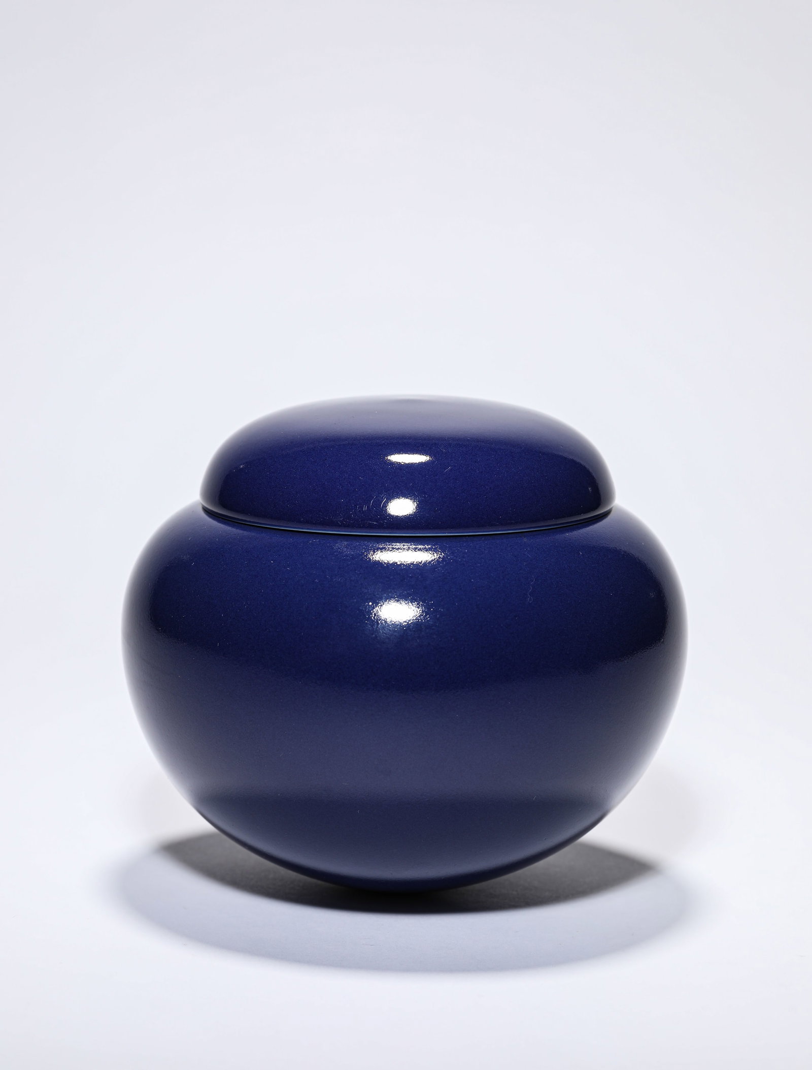 A BLUE-GLAZED COVERED JAR: A BLUE-GLAZED COVERED JAR Dimensions: Width: 14.4 cm (5.67 in) x Height: 12.5 cm (4.92 in). All measurements are approximate.