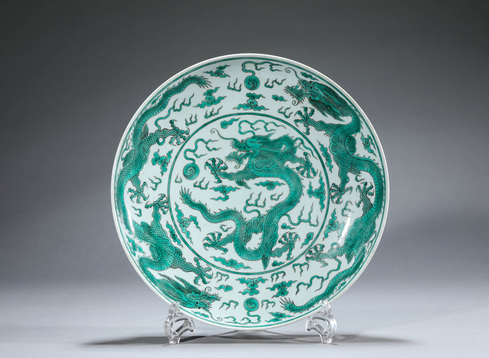 A GREEN-GLAZED 'DRAGON AND CLOUDS' DISH: A GREEN-GLAZED 'DRAGON AND CLOUDS' DISH Dimensions: Width: 32.5 cm (12.80 in) x Height: 5.8 cm (2.28 in). All measurements are approximate.