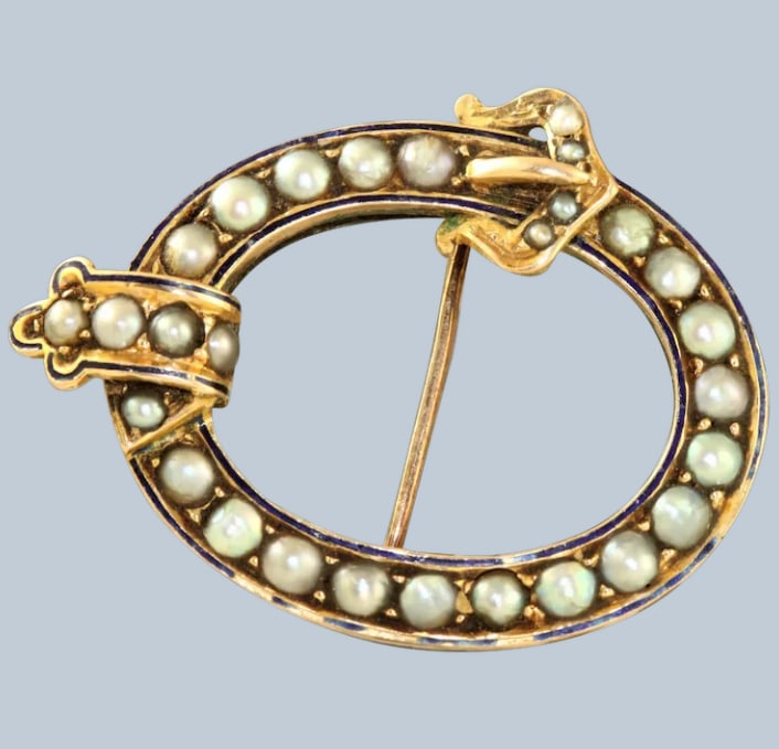 PEARL AND GOLD-TONE BROOCH: PEARL AND GOLD-TONE BROOCH Description: A pearl and gold-tone brooch with a curved open form and pearl accents. Catalogue review should cover pin mechanism, pearl condition, plating wear and missing