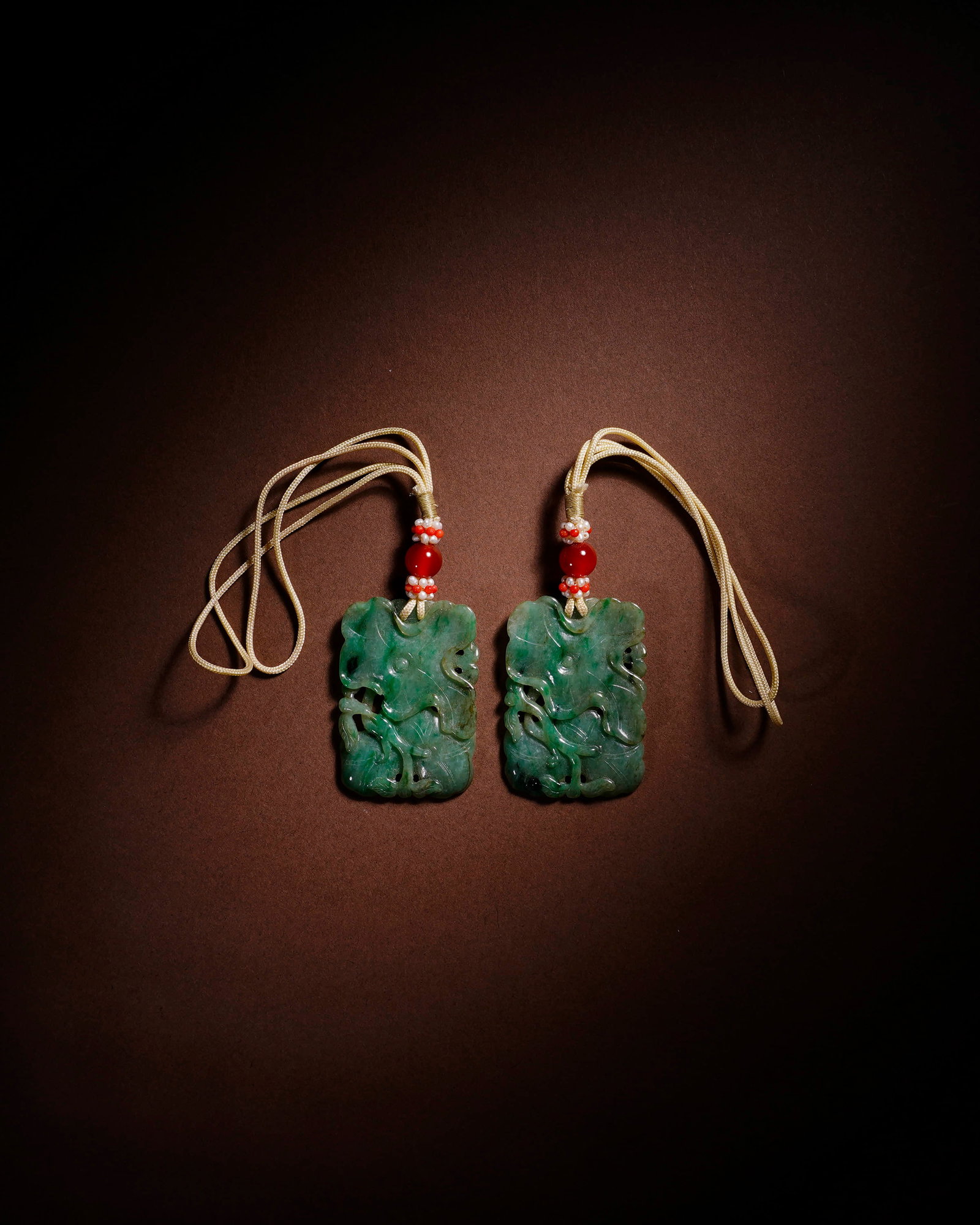 A PAIR OF JADEITE PENDANTS: A PAIR OF JADEITE PENDANTS Dimensions: Length: 3 cm (1.18 in.), Height: 4.4 cm (1.73 in.); Dimensions: Length: 3 cm (1.18 in.), Height: 4.3 cm (1.69 in.). All measurements are approximate.