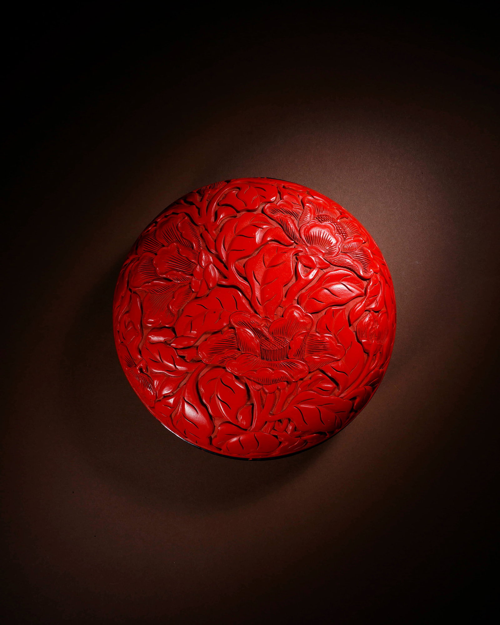 A CARVED CINNABAR LACQUER 'FLOWERS AND WEALTH' COVERED BOX (1 of 3)