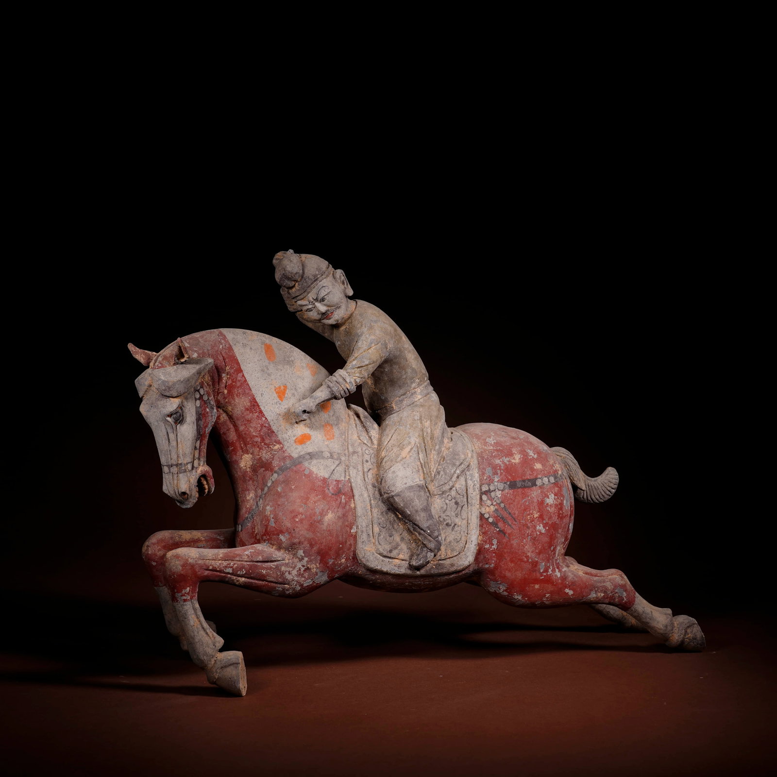 A PAINTED POTTERY 'POLO-PLAYER' FIGURINE: A PAINTED POTTERY 'POLO-PLAYER' FIGURINE Dimensions: Length: 38 cm (14.96 in.), Height: 27 cm (10.63 in.). All measurements are approximate.