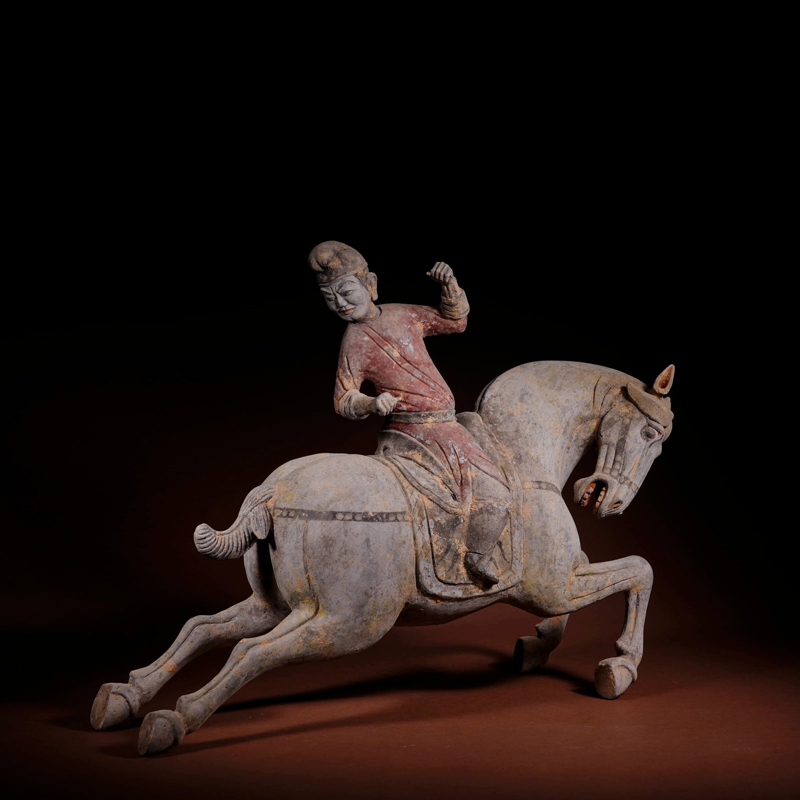 A PAINTED POTTERY 'POLO-PLAYER' FIGURINE: A PAINTED POTTERY 'POLO-PLAYER' FIGURINE Dimensions: Length: 37 cm (14.57 in.), Height: 30 cm (11.81 in.). All measurements are approximate.