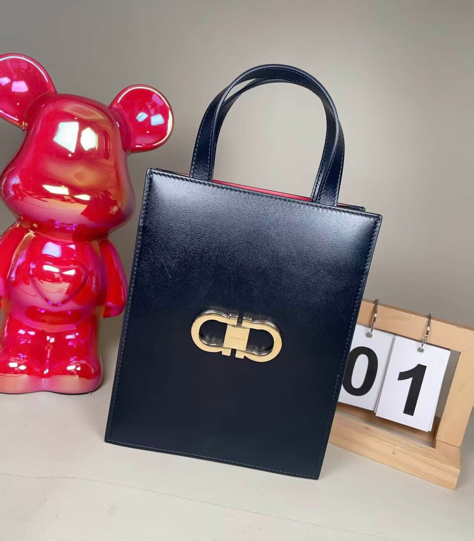 FERRAGAMO BLACK LEATHER HANDBAG: FERRAGAMO BLACK LEATHER HANDBAG Salvatore Ferragamo Black Top-Handle Bag. Crafted from black leather and accented with the house's signature Gancini metal fastening. Designed with a structured