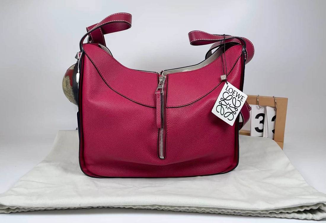 LOEWE HOBO GRAINED CALFSKIN SHOULDER BAG: LOEWE HOBO GRAINED CALFSKIN SHOULDER BAG LOEWE, Hobo. A fuchsia grained calfskin hobo bag with contrasting topstitching, a front zip pocket and an adjustable shoulder strap. Dimensions: 28.5 × 24 ×