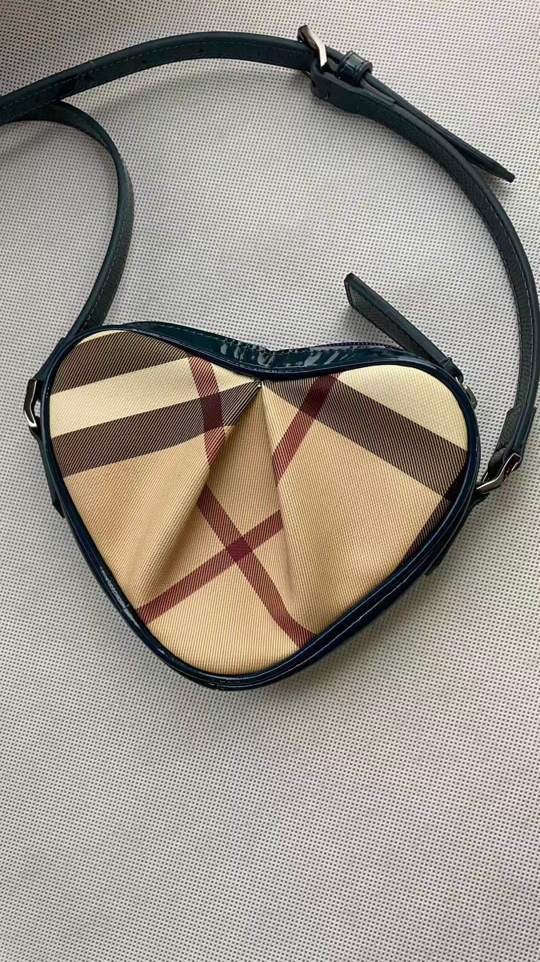 BURBERRY CHECK HEART-SHAPED SHOULDER BAG: BURBERRY CHECK HEART-SHAPED SHOULDER BAG BURBERRY. A heart-shaped shoulder and crossbody bag in signature check textile with contrasting blue leather trim. Unused condition.