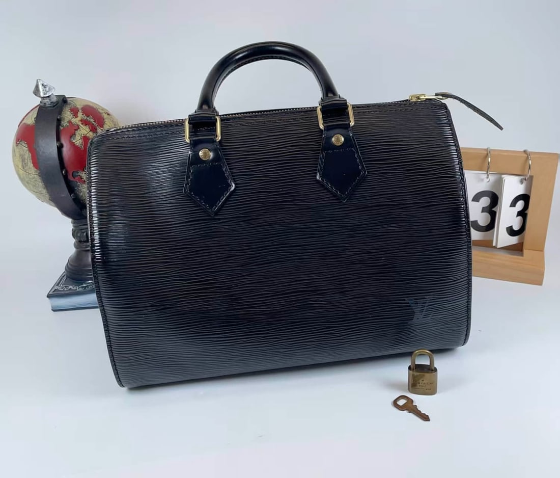 LOUIS VUITTON SPEEDY EPI LEATHER HANDBAG: LOUIS VUITTON SPEEDY EPI LEATHER HANDBAG LOUIS VUITTON, Speedy. A black Epi leather top-handle bag of classic Boston form, finished with leather handles, metal fittings and a lock closure.