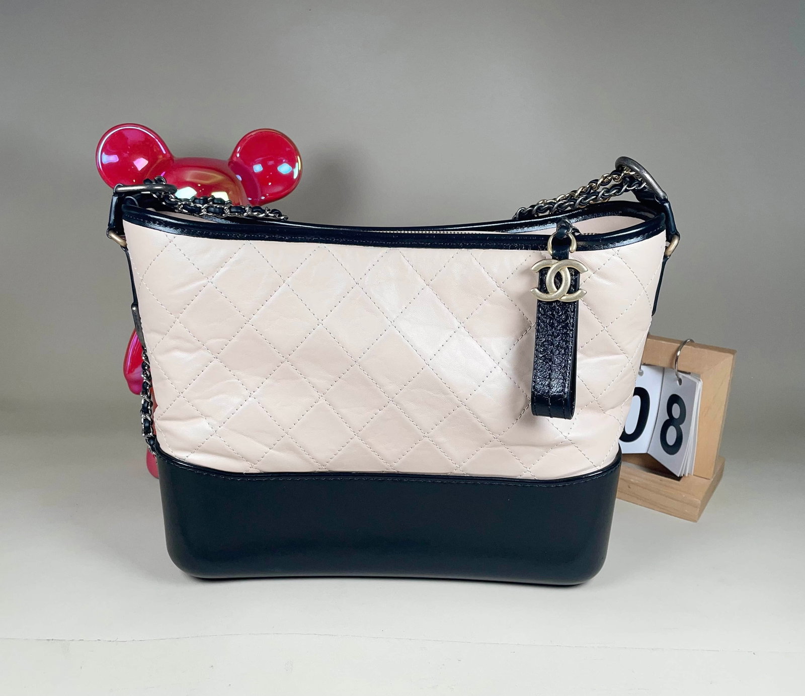 CHANEL GABRIELLE BLACK-AND-WHITE LEATHER HOBO BAG: CHANEL GABRIELLE BLACK-AND-WHITE LEATHER HOBO BAG CHANEL, Gabrielle Hobo. A black-and-white leather shoulder bag with a contrasting red interior, bearing a 26-series serial number. Reportedly carried