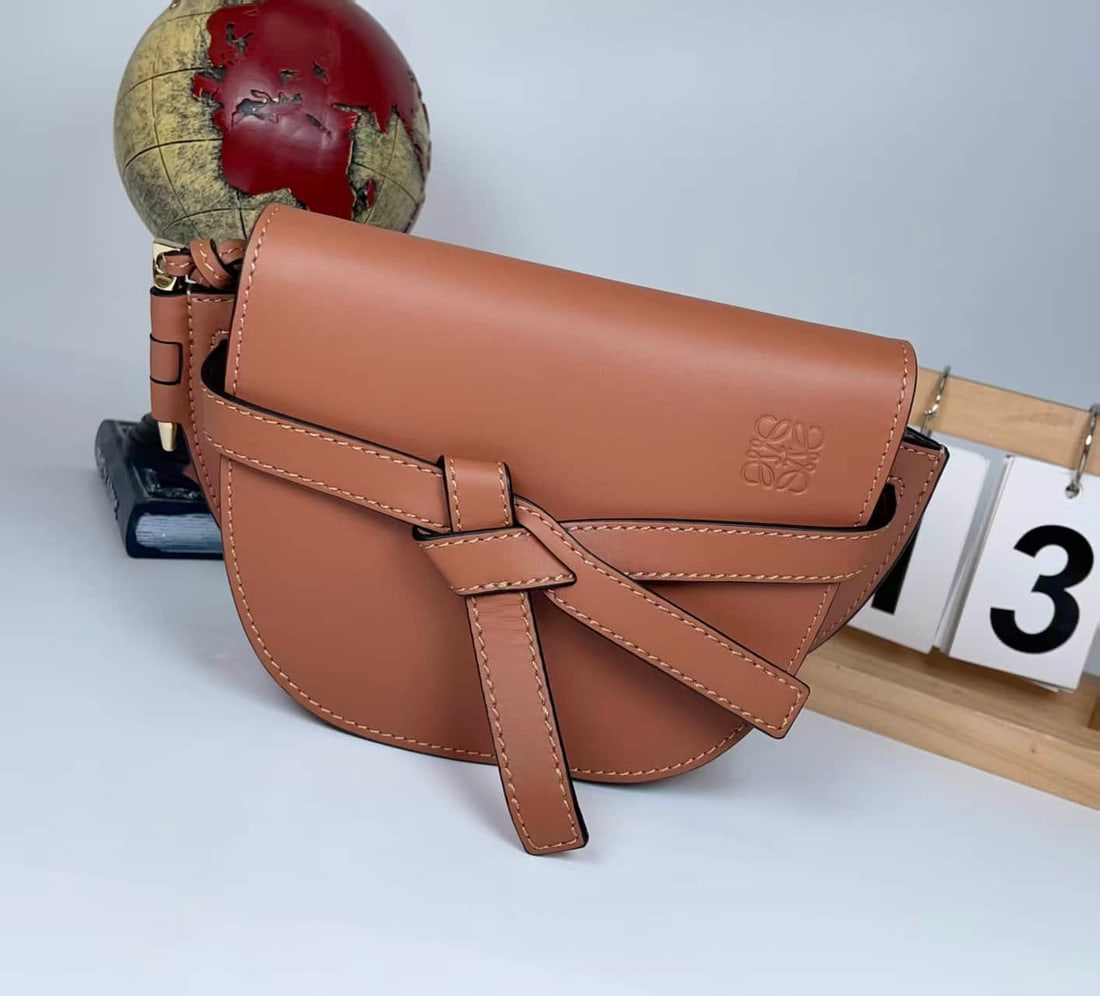LOEWE GATE CARAMEL CALFSKIN BELT BAG: LOEWE GATE CARAMEL CALFSKIN BELT BAG LOEWE, Gate. A caramel-coloured calfskin belt bag featuring the model's characteristic knotted leather detail, embossed branding, magnetic closure and an